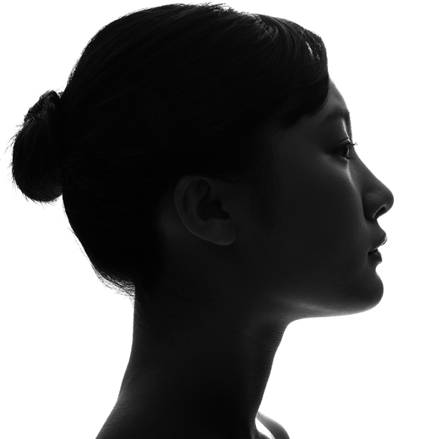 Fotografía del perfil oscurecido de una mujer con rasgos asiáticos. 